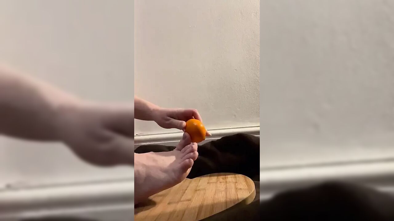 Bare feet crushing and orange