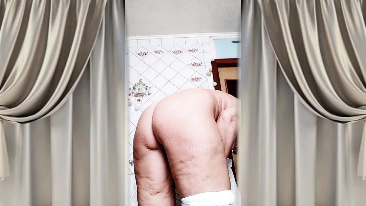 Hot housewife Lukerya flirts in an open transparent white jumpsuit in the kitchen 2