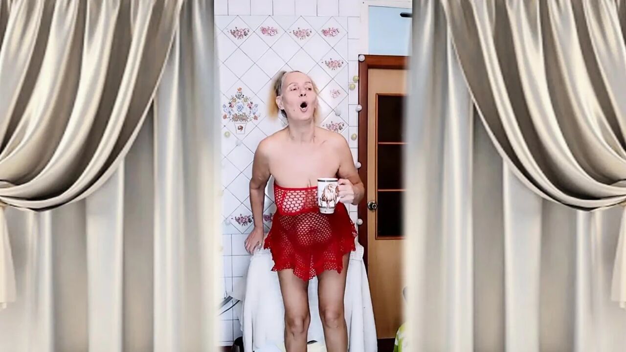 Hot housewife Lukerya flirts over morning coffee in a red mesh dress.